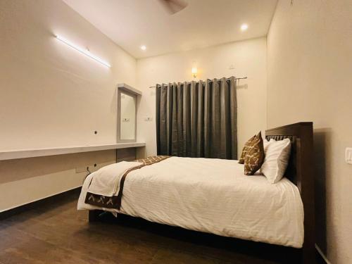 una camera da letto con un letto grande con una finestra di The Forest Grove by Living Circle a Yelagiri