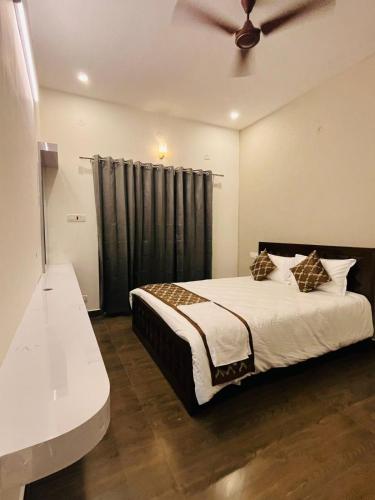 a bedroom with a bed and a ceiling fan at The Forest Grove by Living Circle in Yelagiri