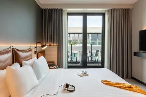 a hotel room with a bed and a balcony at Moxy Brussels City Center in Brussels