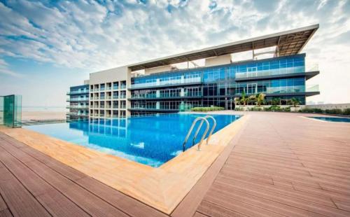 アブダビにあるLuxury Saadiyat Fully Equipped Apartmentの前にプールがある建物
