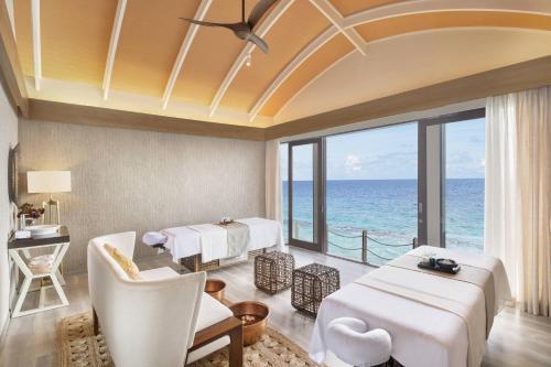 a room with two beds and a view of the ocean at JW Marriott Maldives Resort & Spa in Funadhoo
