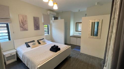- une chambre avec un lit et des serviettes noires dans l'établissement Un Havre de Paix Entre Mer et Montagne à L'ile Maurice!, à Petite Case Noyale