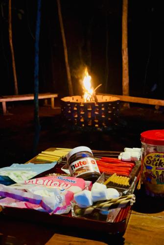 a picnic table with a candle and a basket of food at Tagaytay's Cozy Loft-type Forest House and Camp in Silang