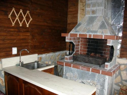 eine Küche mit einem Backsteinofen und einer Spüle in der Unterkunft Andreevite Houses in Saparewa Banja