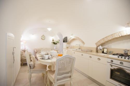 a white kitchen with a table and chairs in it at Gnostre Holidays in Noci