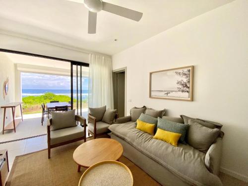 a living room with a couch and a table at Beachfront Luxury 3 Bedrooms Apartment in Poste Lafayette