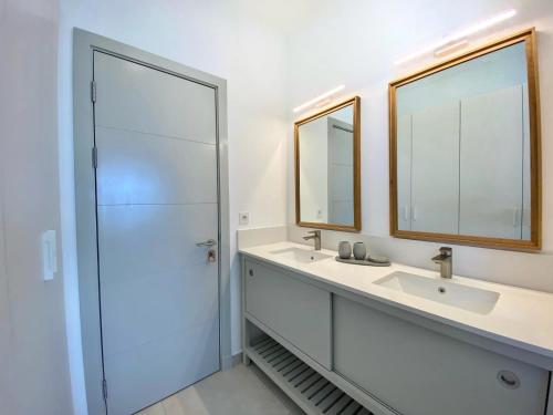 a bathroom with two sinks and two mirrors at Beachfront Luxury 3 Bedrooms Apartment in Poste Lafayette
