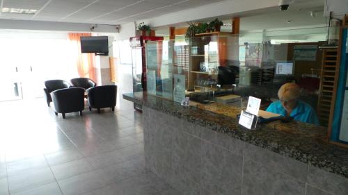 a person sitting at a counter in a restaurant at Apartamentos Beni-Beach in Benidorm