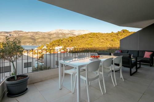 a white table and chairs on a balcony with a view at Korcula Luxury Apartments in Korčula