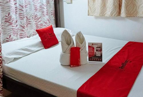 a bed with red and white decorations on it at RedDoorz @ Gaea's Apartment Panglao in Panglao