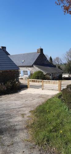 une clôture en bois devant une maison dans l'établissement Kalon Bihan Gîte, à Poullaouen