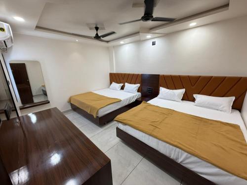 ドワルカにあるHOTEL SHREE GANESH DWARKaのベッド2台とテーブルがあるホテルの部屋