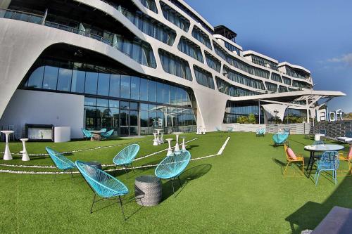 a group of chairs and tables in front of a building at Aloft Ponce Hotel & Casino in Ponce