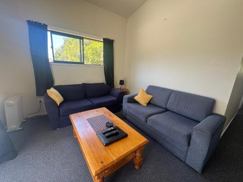 a living room with two couches and a coffee table at Bay Road Motels in Haast