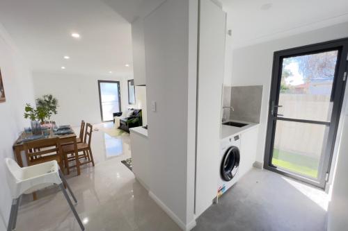a kitchen and living room with a washer and dryer at B3 Near Airport - Cozy Home, Walk to Shops & Eats in Perth