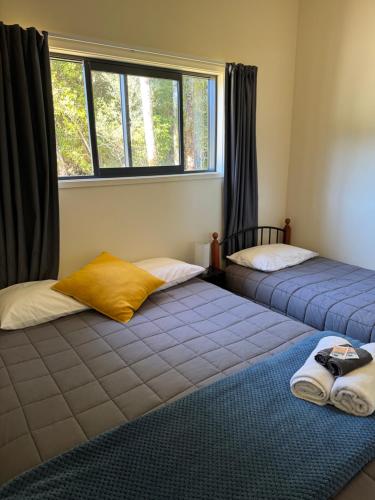two beds sitting in a room with a window at Bay Road Motels in Haast