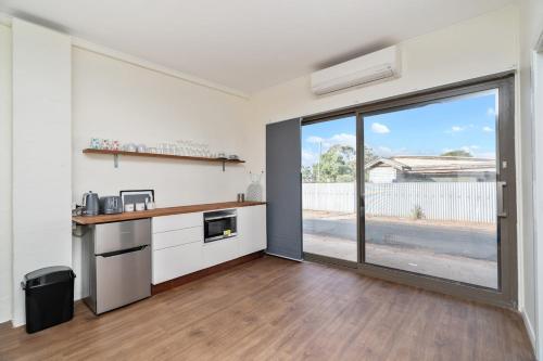 a kitchen with a counter and a large sliding glass door at Central Studio - 290A Little Baker in Temora