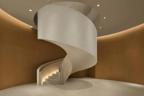 a spiral staircase in a room with brown walls at The Singapore EDITION in Singapore