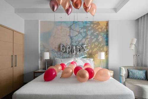 a bedroom with a bed with a bunch of pillows at Courtyard by Marriott Port of Spain in Port-of-Spain