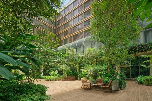 a courtyard with trees and chairs and a building at The Singapore EDITION in Singapore