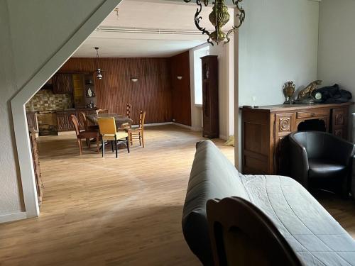 un salon avec un canapé, une table et des chaises dans l'établissement Grande Maison de Campagne proche de Carhaix, à Plévin