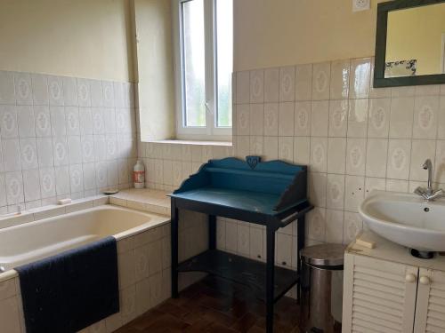 une salle de bain avec une baignoire et un lavabo et une baignoire dans l'établissement Grande Maison de Campagne proche de Carhaix, à Plévin