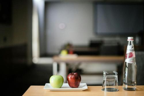 a bottle of soda and two apples on a table at Courtyard by Marriott Port of Spain in Port-of-Spain