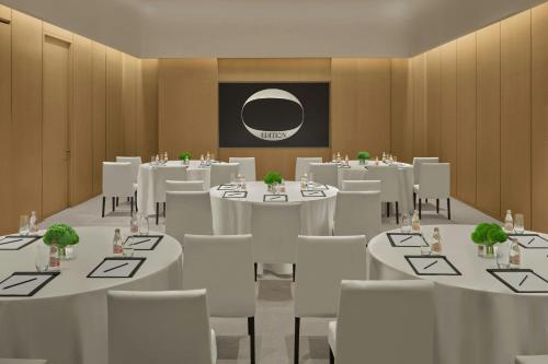 a conference room with white tables and white chairs at The Singapore EDITION in Singapore