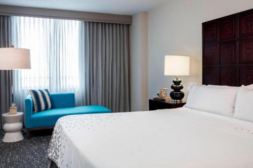 a hotel room with a bed and a blue chair at Renaissance Fort Lauderdale Cruise Port Hotel in Fort Lauderdale