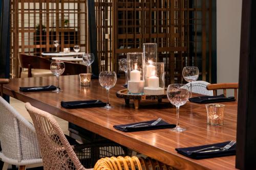 a wooden table with wine glasses and candles on it at Renaissance Fort Lauderdale Cruise Port Hotel in Fort Lauderdale