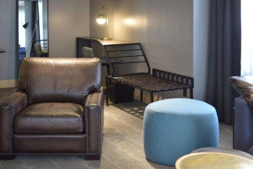 a living room with a chair and a stool at Renaissance Reno Downtown Hotel & Spa in Reno