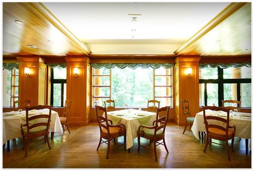 - une salle à manger avec des tables, des chaises et des fenêtres dans l'établissement Chuzenji Kanaya Hotel, à Nikkō