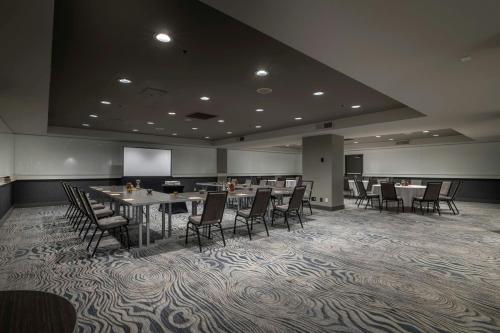 a conference room with tables and chairs and a screen at Renaissance Reno Downtown Hotel & Spa in Reno