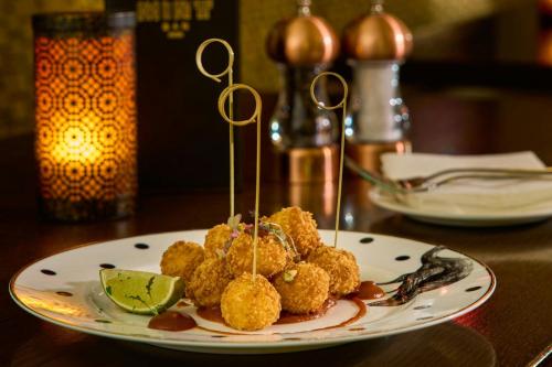 a plate of food with tater tots on a table at The College Green Dublin Hotel, Autograph Collection in Dublin