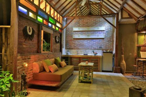 a living room with a couch and a kitchen at Villas SAMALAMA Gili Trawangan in Gili Trawangan