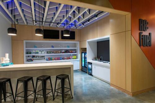 a kitchen with three bar stools and a counter at Aloft Providence Downtown in Providence