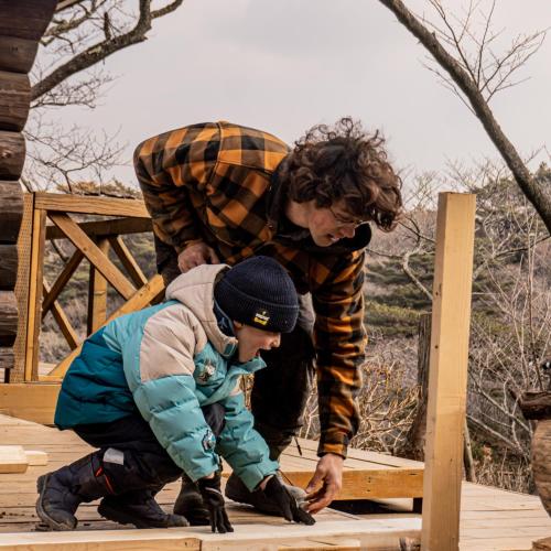 a woman and a child playing with a wooden structure at RENEST in Kobe