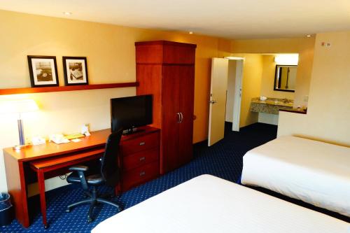 a hotel room with a desk with a computer and a bed at Courtyard Monterrey San Jeronimo in Monterrey