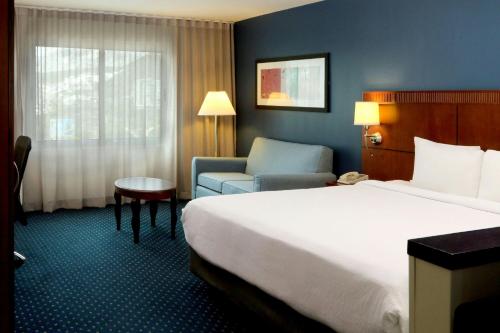 a hotel room with a bed and a chair at Courtyard Monterrey San Jeronimo in Monterrey