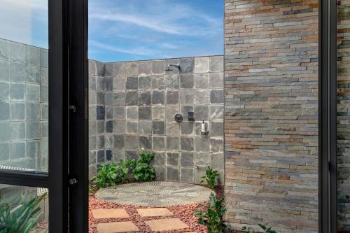 a shower in a brick wall at African Pride Melrose Arch, Autograph Collection in Johannesburg