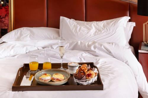 a tray of food and drinks on a bed at African Pride Melrose Arch, Autograph Collection in Johannesburg