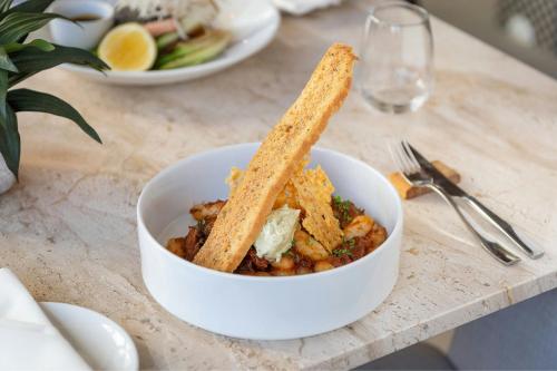 a bowl of food sitting on a table at African Pride Melrose Arch, Autograph Collection in Johannesburg