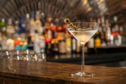 a martini glass sitting on top of a bar at African Pride Melrose Arch, Autograph Collection in Johannesburg