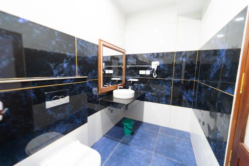 a bathroom with a sink and a toilet and a mirror at Skylar Seaview Beach Resort & Ayurveda Varkala in Varkala