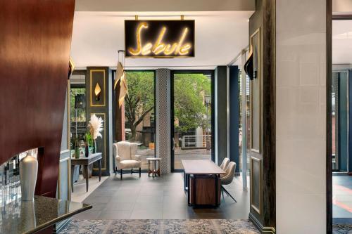 a lobby of a hotel with a table and chairs at African Pride Melrose Arch, Autograph Collection in Johannesburg