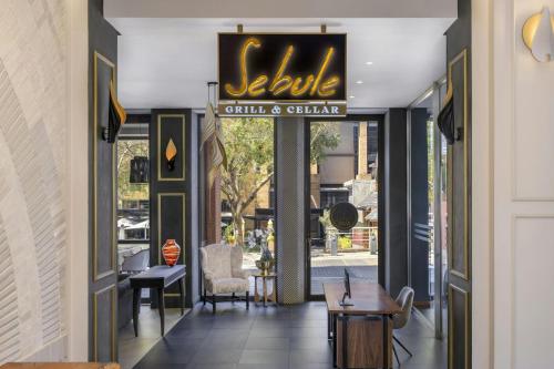 a restaurant entrance with a sign that reads settle still and chain at African Pride Melrose Arch, Autograph Collection in Johannesburg