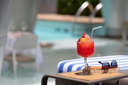 a drink sitting on a table next to a pool at African Pride Melrose Arch, Autograph Collection in Johannesburg