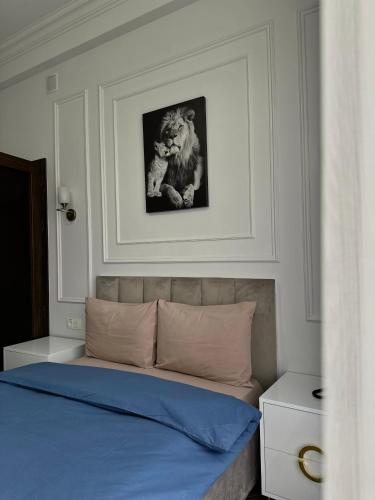 a bedroom with a bed with a lion picture on the wall at Fiorella Gyumri in Gyumri