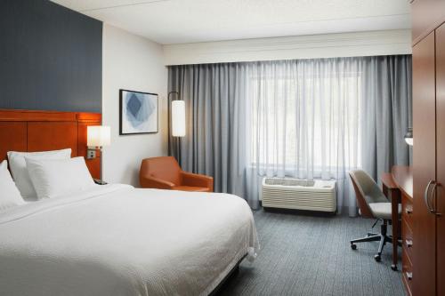 a hotel room with a bed and a chair and a window at Courtyard by Marriott Boone in Boone