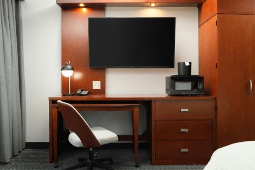 a room with a desk with a television and a chair at Courtyard by Marriott Boone in Boone